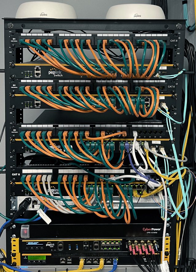 Peplink switch and AP rack — carrier NOC infrastructure powering wholesale SD-WAN